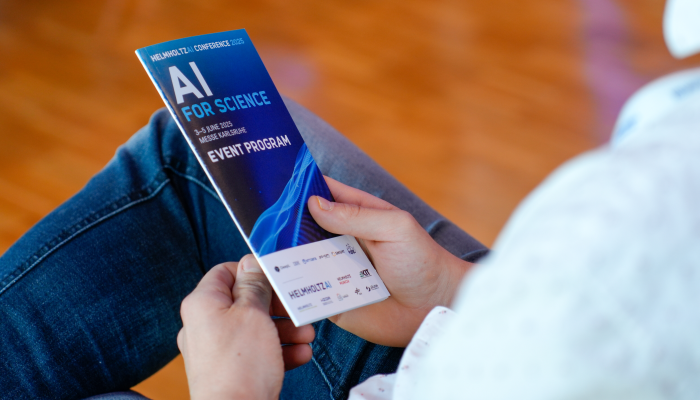 A conference participant holds the conference program flyer in his hand.