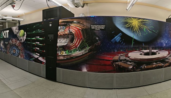 Blick in den Rechnerraum in dem die Tape-Library steht. Auf dem Foto sieht man in der Panoramaperspektive einen Teil der gesamten Längsansicht mit den Aufdrucken mit Photo-Motiven des CERN und des SCC