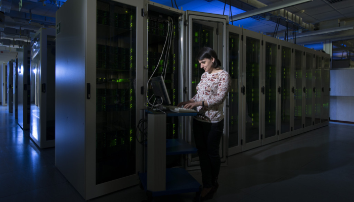 An experiment representative stands at the console in the GridKa computer room, servicing a system.