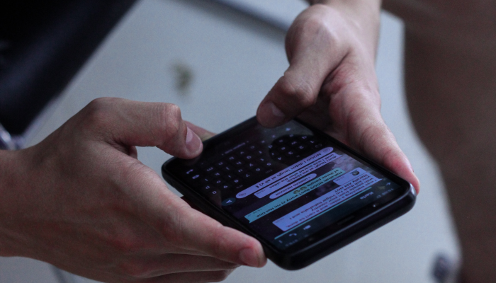 Person chattet in einem Chat-Tool auf dem Smartphone